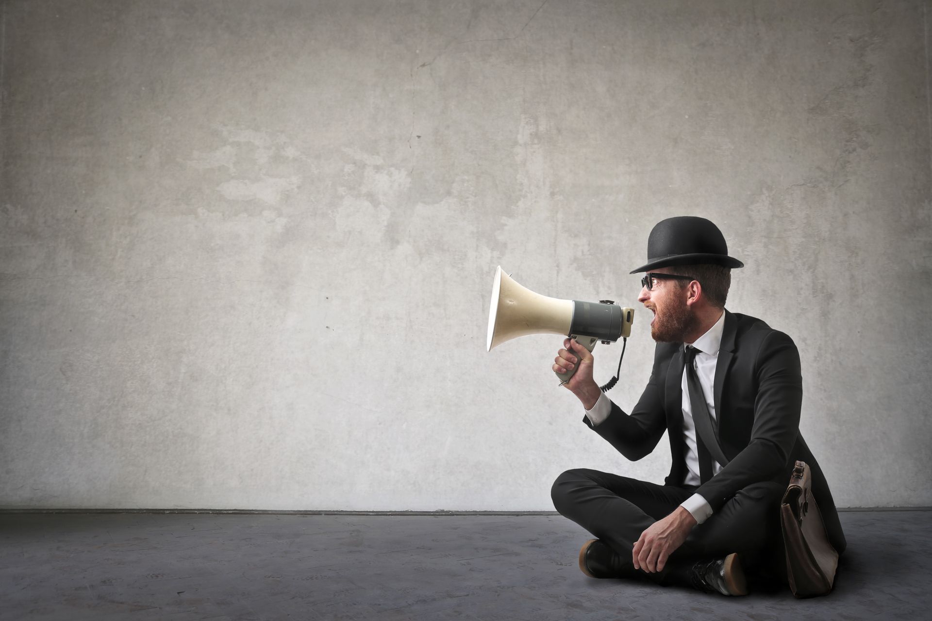 Un uomo parla al megafono davanti a un muro: il messaggio uguale per tutti