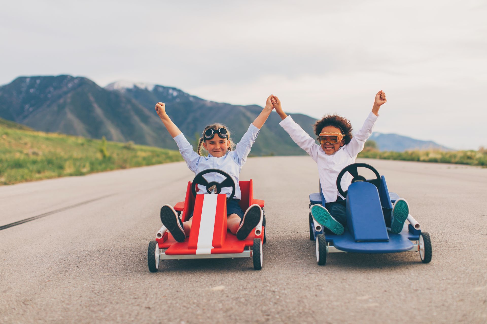 Two children on two go-karts side by side, each winning their own race